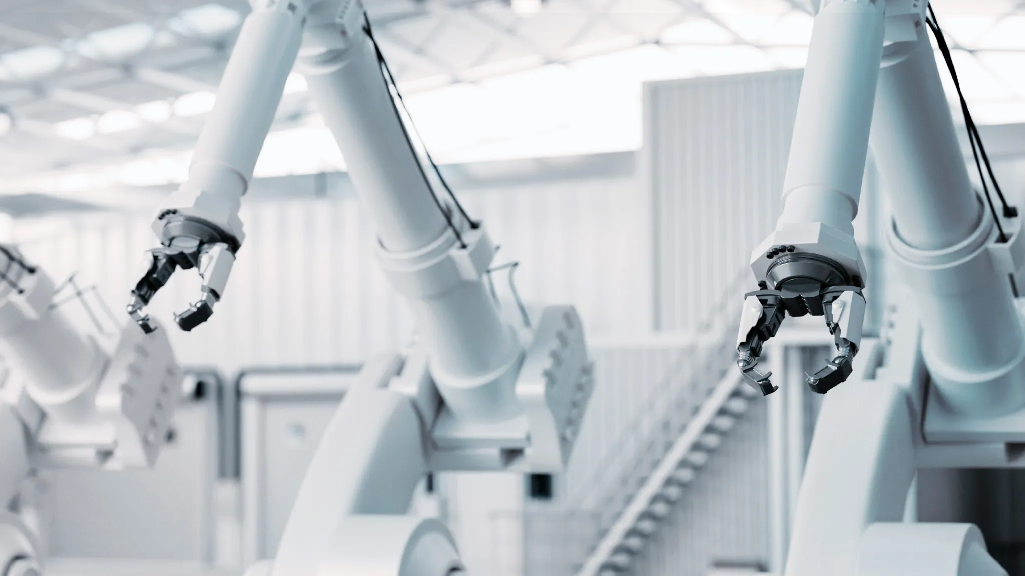 Weiße Roboterarme in weißer Industriehalle